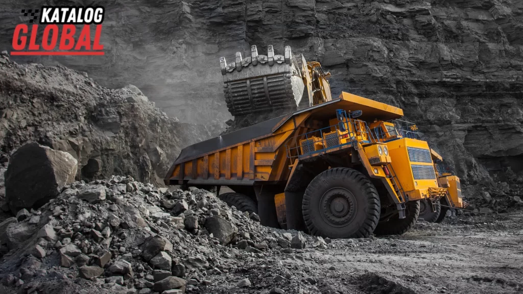 A large mining truck being loaded with rocks by an excavator at a quarry site. Can you have your own mining company? Discover the heavy-duty machinery needed for mining.