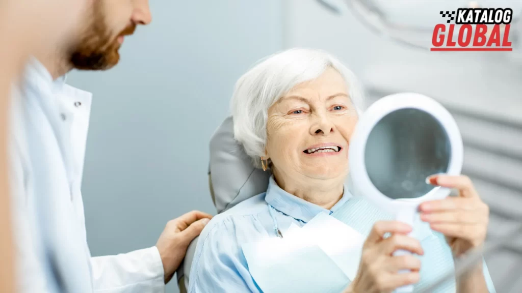 How Much Do Dental Implants Cost? Elderly woman examining her new dental implants in a mirror at the dentist